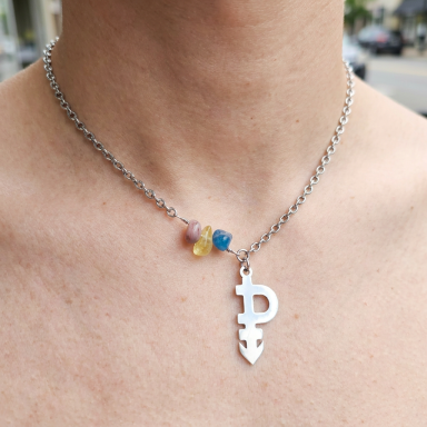 The Pansexual Pride Statement Necklace Close-up of a model wearing a premium stainless steel pansexual lifestyle symbol necklace with integrated pink, yellow, and blue crystal acc